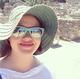 Close-up of Caroline wearing sunglasses and a sunhat