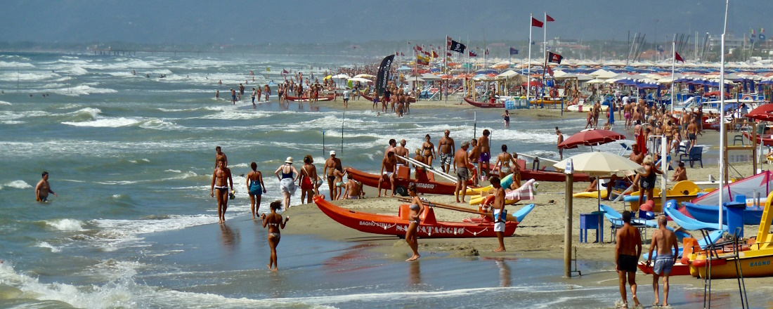 Rough waves on a busy sunny beach