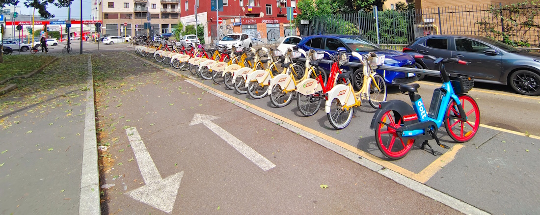 Bicycle parking racks on the side of a Milanese street