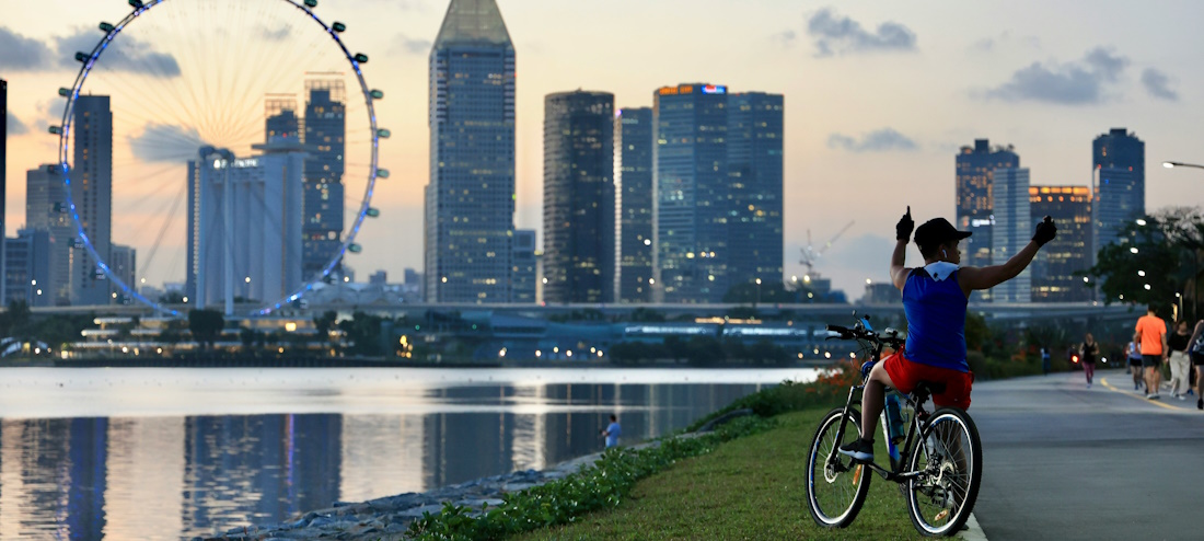 Cyclist resting in view of Marina Bay Ferris Wheel