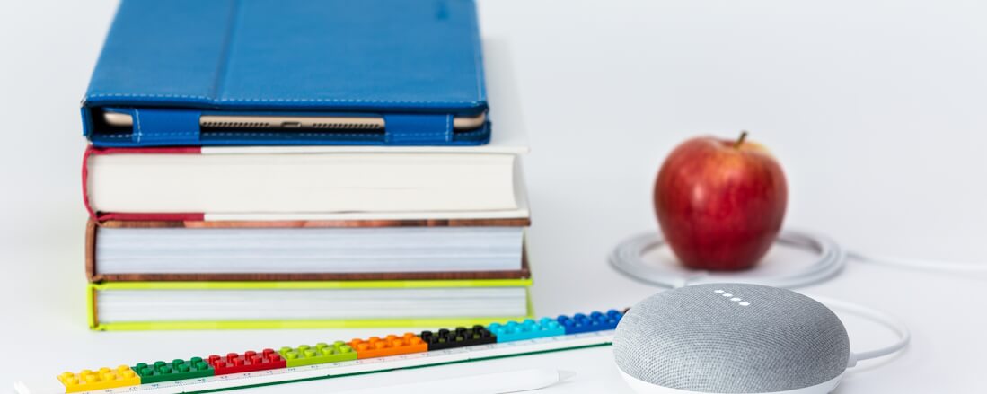 Books, a tablet, stationery and an apple