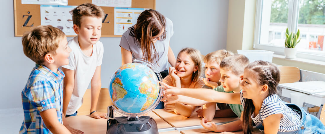 School children pointing at globe