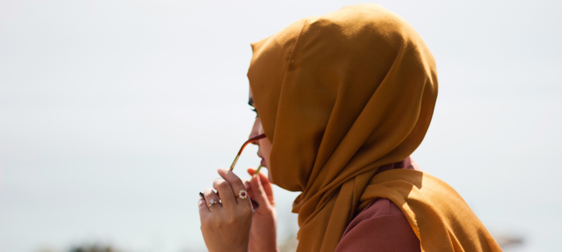 hijabi woman putting on sunglasses