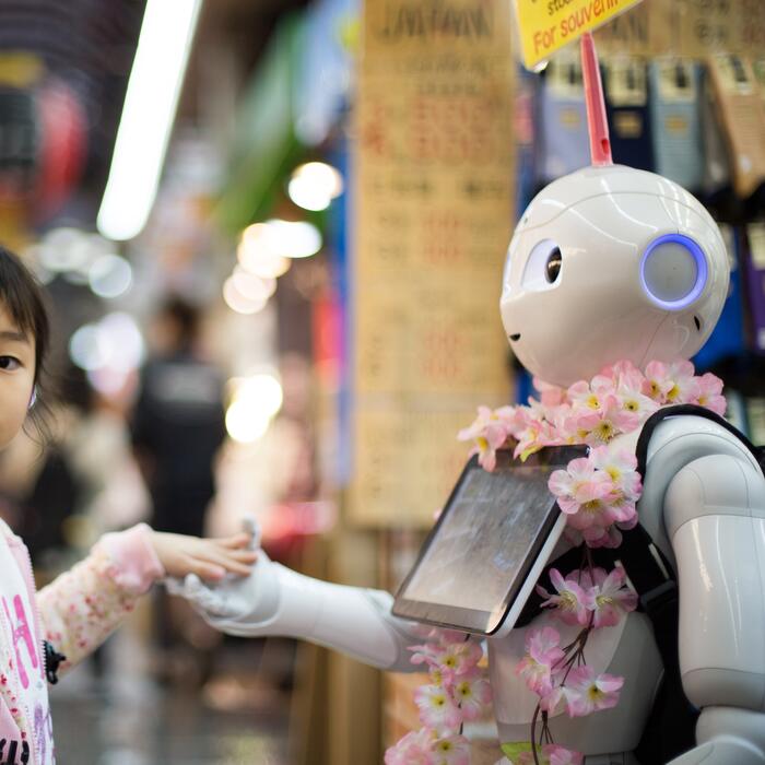 Photo of a girl making friends with a robot
