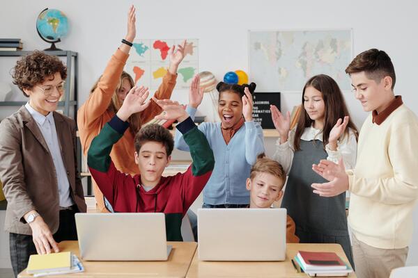 Children cheering together in classroom by Max Fischer from Pexels